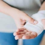 woman showing her bandaged left hand